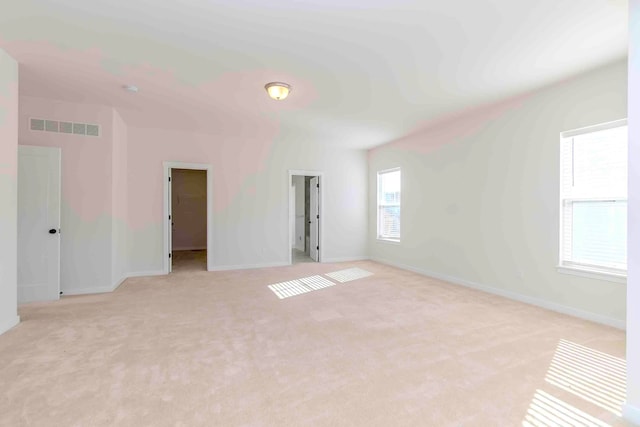 unfurnished room featuring light carpet and plenty of natural light