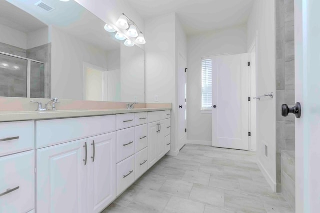 bathroom with vanity and a shower with shower door