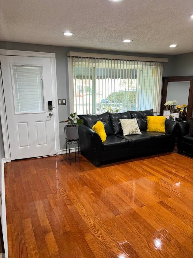 living room featuring wood-type flooring and a textured ceiling