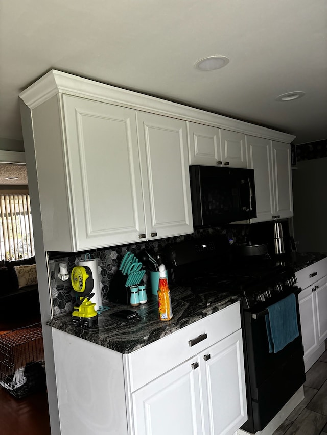 kitchen featuring tasteful backsplash, black appliances, dark stone countertops, white cabinets, and dark hardwood / wood-style floors