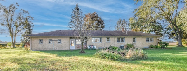 rear view of house featuring a lawn