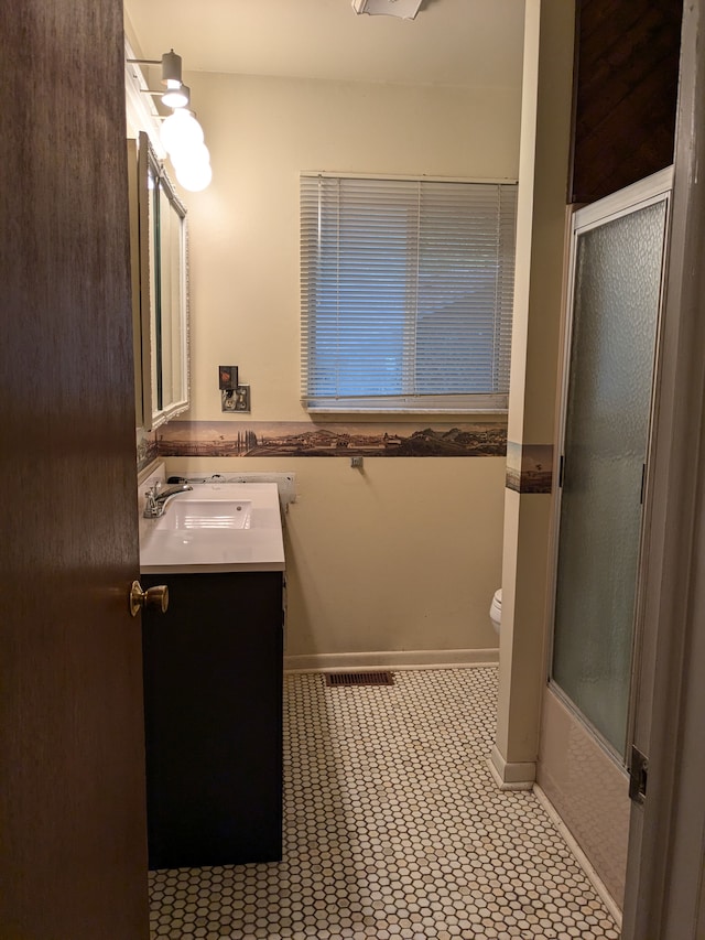 full bathroom with combined bath / shower with glass door, vanity, tile patterned floors, and toilet