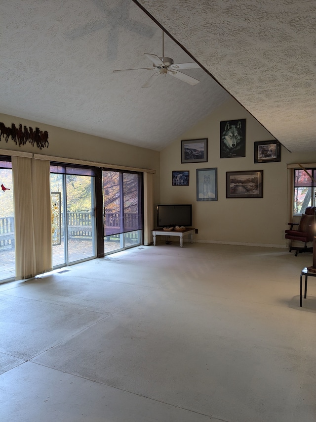 unfurnished living room featuring ceiling fan, lofted ceiling, and a textured ceiling