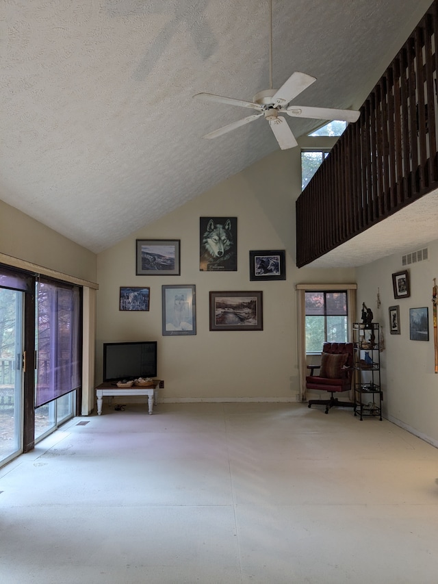 living room featuring a textured ceiling, vaulted ceiling, and ceiling fan