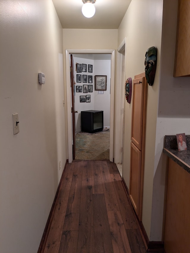 corridor with dark hardwood / wood-style flooring