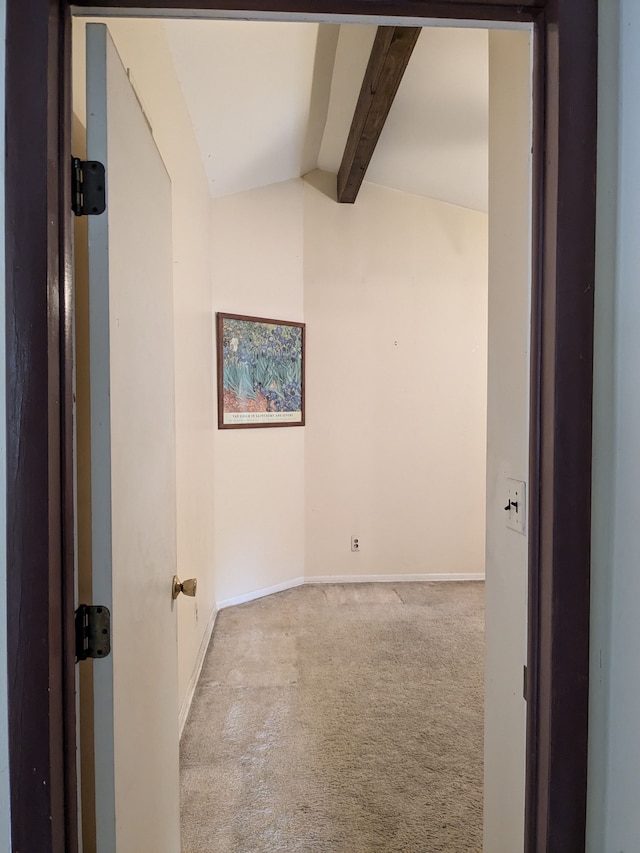 unfurnished room featuring lofted ceiling with beams and light carpet