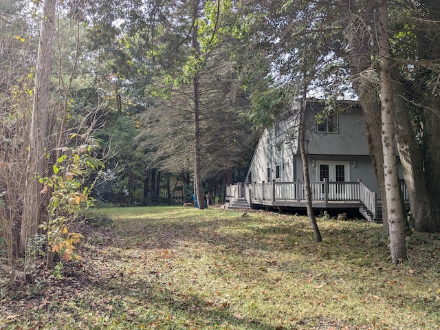 view of yard featuring french doors and a deck