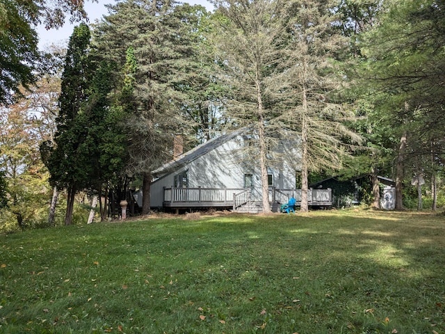 view of side of property with a lawn and a wooden deck