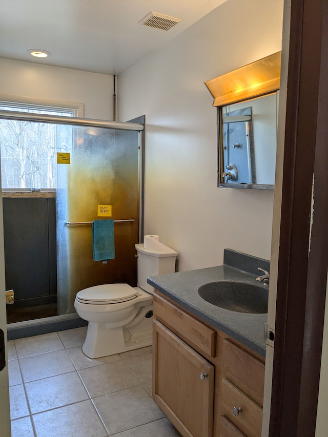 bathroom with tile patterned flooring, vanity, toilet, and an enclosed shower