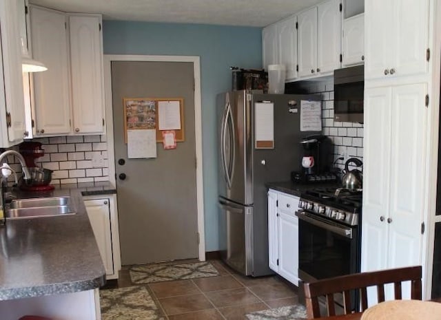 kitchen featuring decorative backsplash, stainless steel appliances, white cabinetry, and sink