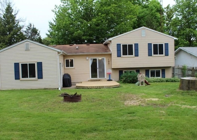 back of house with a yard and an outdoor fire pit