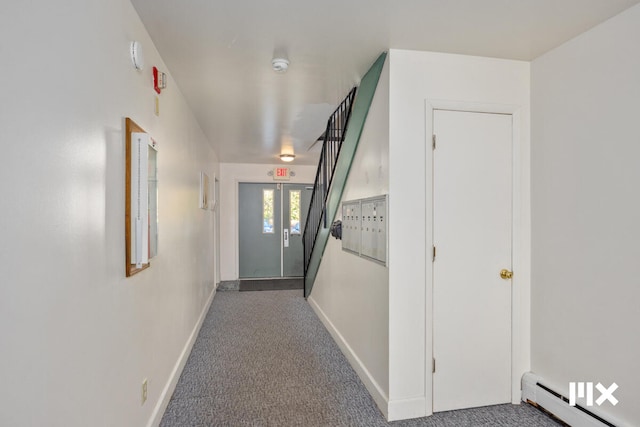 corridor with carpet floors and a baseboard heating unit