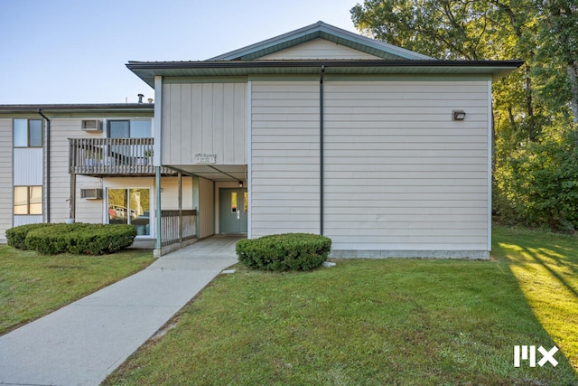 view of front of house with a front yard and a balcony