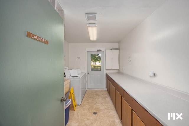 laundry area with washer and dryer and cabinets