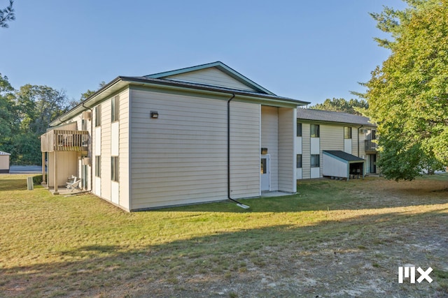 rear view of property featuring a lawn and a wooden deck