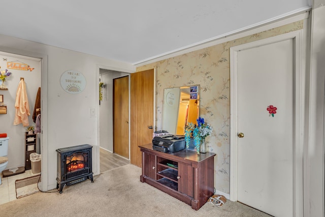 interior space featuring light colored carpet and a wood stove