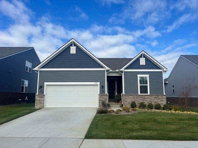 craftsman-style home featuring a garage and a front yard