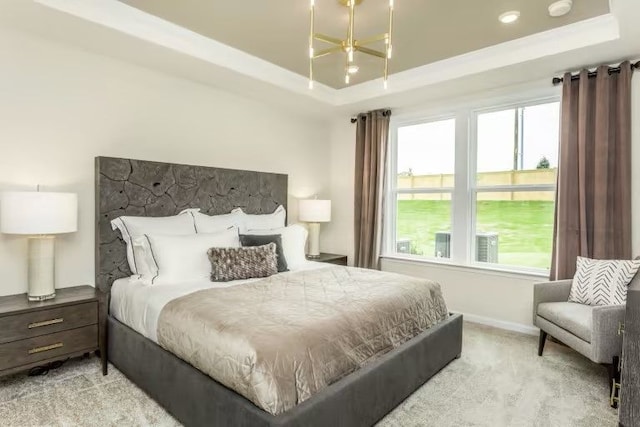 bedroom featuring light colored carpet and a raised ceiling