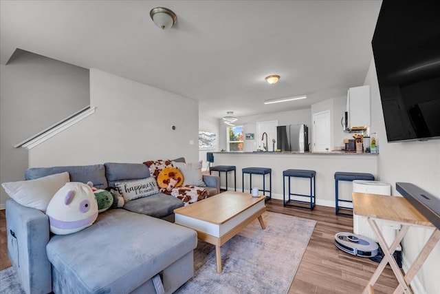 living room featuring sink and light hardwood / wood-style flooring