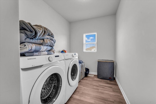 laundry room with washer and clothes dryer and light wood-type flooring