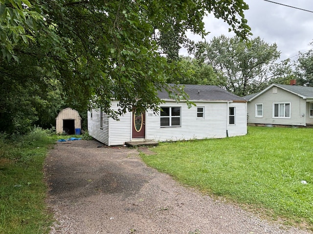 view of front facade with a front yard and a storage unit