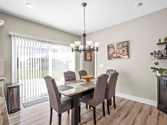 dining space featuring light hardwood / wood-style floors and an inviting chandelier