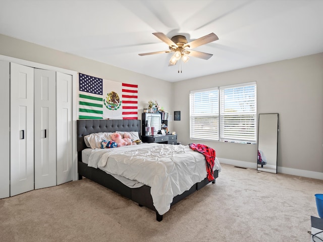 bedroom with light carpet, a closet, and ceiling fan