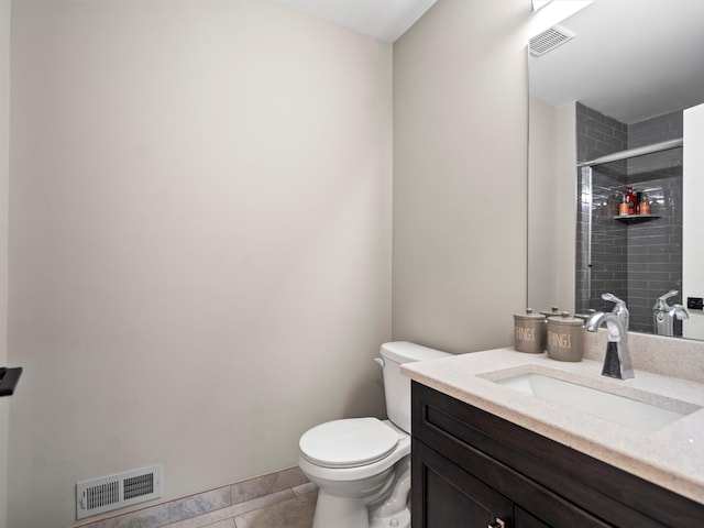 bathroom featuring tile patterned flooring, vanity, toilet, and walk in shower