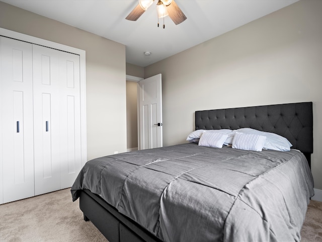 bedroom featuring a closet, light colored carpet, and ceiling fan