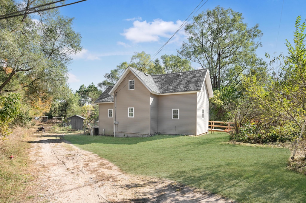 14 2nd St, Stanwood, MI 49346 - view of home's exterior with a shingled roof, central AC, and dirt driveway
