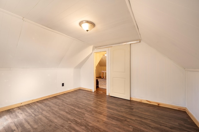 bonus room with dark wood-type flooring and vaulted ceiling