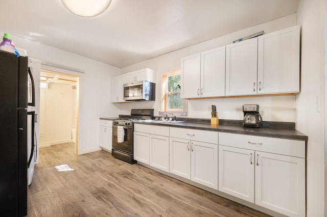 kitchen with black appliances, light hardwood / wood-style floors, white cabinets, and sink