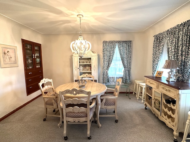 dining space with carpet floors and a notable chandelier