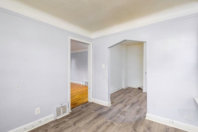 empty room featuring crown molding and light hardwood / wood-style flooring