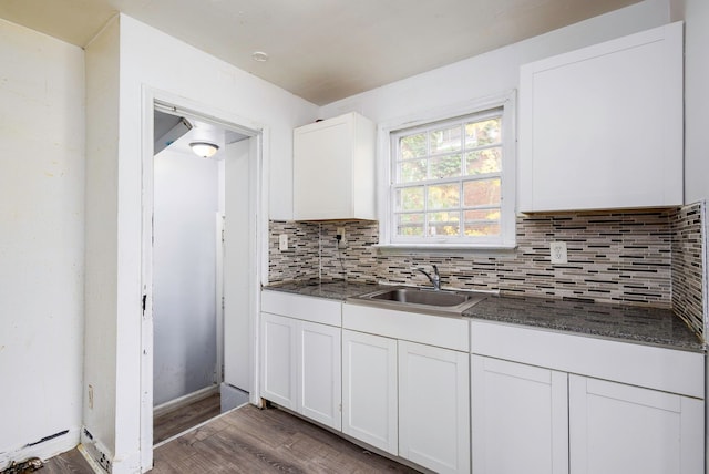 kitchen featuring decorative backsplash, dark wood-type flooring, sink, dark stone countertops, and white cabinets