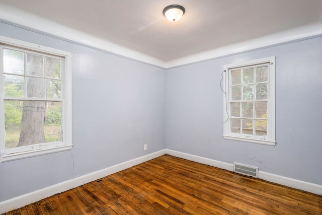 unfurnished room with a wealth of natural light and hardwood / wood-style flooring