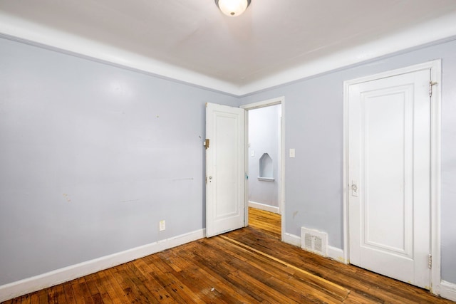 unfurnished bedroom with dark hardwood / wood-style flooring