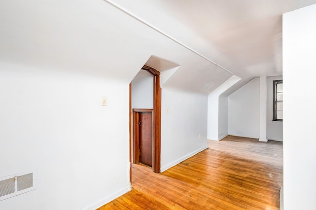 additional living space with lofted ceiling and light wood-type flooring