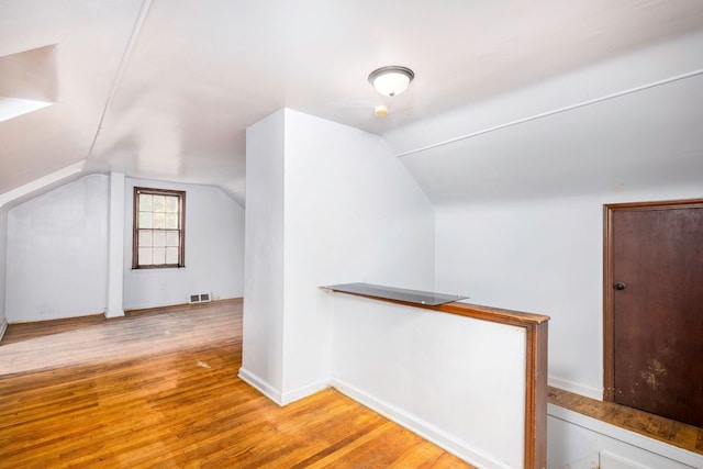 bonus room with vaulted ceiling and light hardwood / wood-style flooring