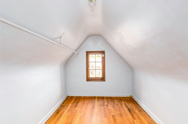 additional living space featuring light hardwood / wood-style flooring and vaulted ceiling