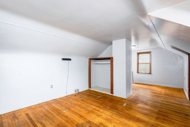 bonus room featuring wood-type flooring and vaulted ceiling