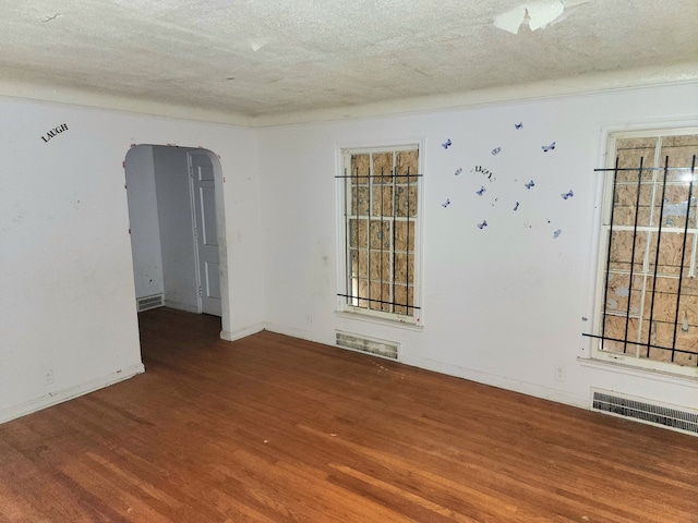 spare room with a textured ceiling and hardwood / wood-style flooring