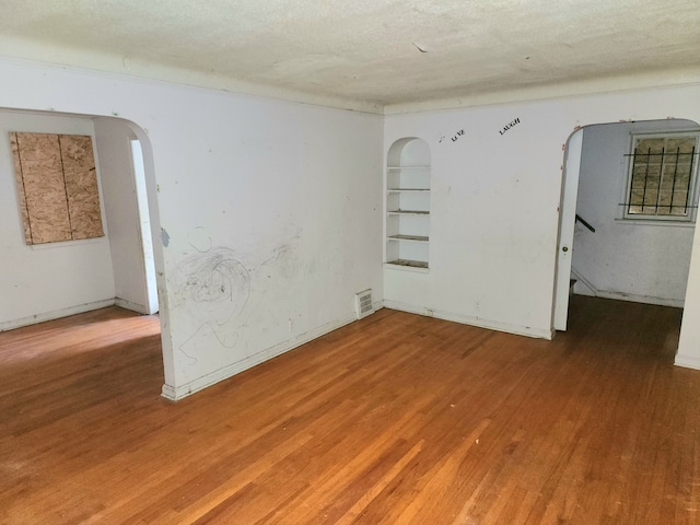 spare room featuring a textured ceiling and hardwood / wood-style flooring