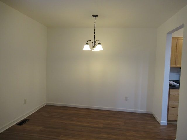 unfurnished dining area featuring a chandelier and dark hardwood / wood-style flooring