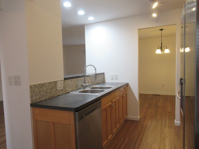 kitchen featuring sink, decorative light fixtures, a notable chandelier, dark hardwood / wood-style flooring, and stainless steel appliances