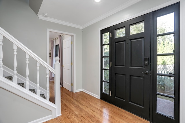 entrance foyer featuring light hardwood / wood-style flooring, plenty of natural light, and crown molding