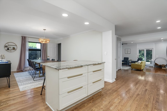 kitchen featuring pendant lighting, light hardwood / wood-style floors, white cabinetry, and plenty of natural light