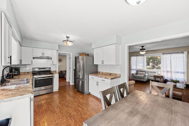 kitchen with sink, dark wood-type flooring, white cabinets, and appliances with stainless steel finishes