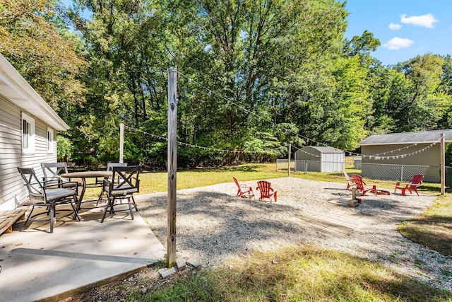 view of yard featuring a patio, a storage unit, and an outdoor fire pit