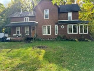 rear view of property with a lawn